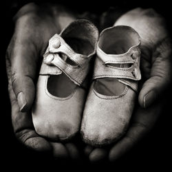 Close-up of hands holding baby shoes