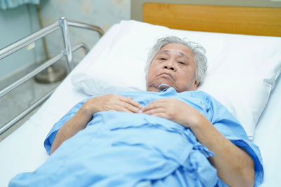 Portrait of senior female patient relaxing on bed at hospital