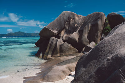 Rock formation on beach against sky