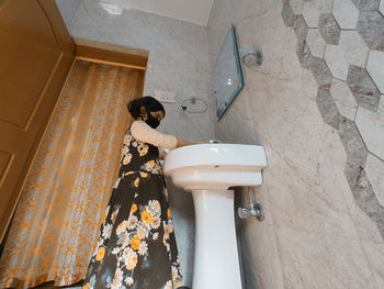 High angle view of woman standing in bathroom