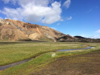 Scenic view of lake by mountains against sky