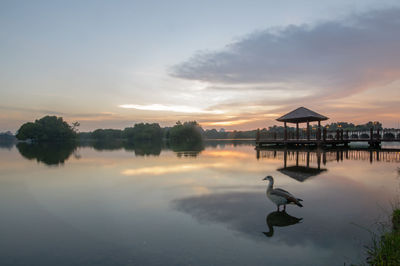 Scenic view of lake against sky at sunset