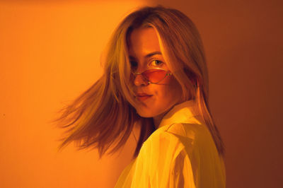 Portrait of woman against orange background