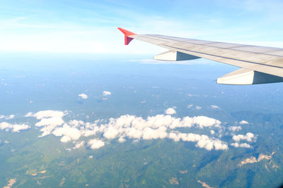 Airplane flying over landscape against sky