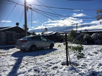 Cars on snow covered mountain against sky