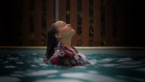 Woman with eyes closed in swimming pool