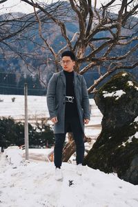 Man standing on snow against trees