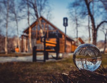 Reflection of houses and trees on crystal ball on wood