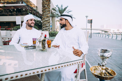 Smiling business people having discussion while sitting at cafe