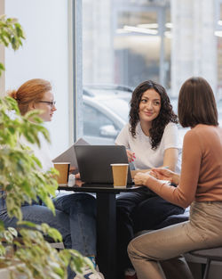Businesswomen talking while sitting at cafe