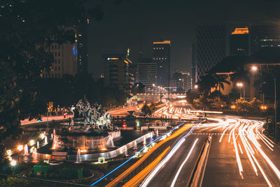 High angle view of illuminated street amidst buildings at night