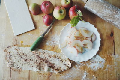 Close-up of dough and apples on table