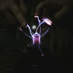 Close-up of man holding illuminated lighting equipment