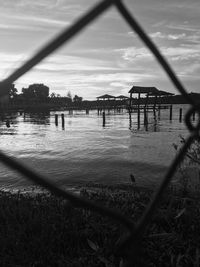 Scenic view of river seen through chainlink fence