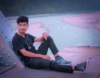 Portrait of young man sitting outdoors