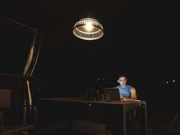 Mature man using laptop on table at home during night