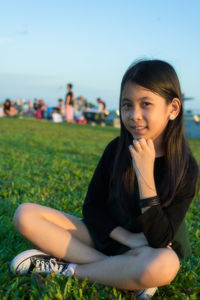 Portrait of smiling girl sitting on grassy field