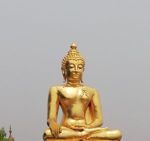 Low angle view of statue against temple against sky