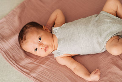 Portrait of cute baby lying on sofa at home