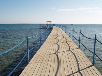 Pier over sea against clear sky