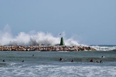 People on beach against clear sky