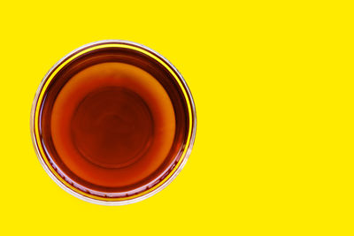 Directly above shot of tea cup against yellow background