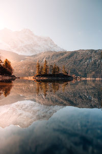 Scenic view of lake by mountains against sky