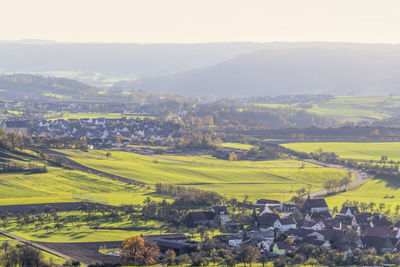 High angle view of agricultural field and houses against sky