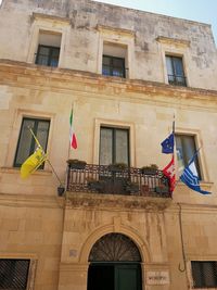 Low angle view of flags hanging on building