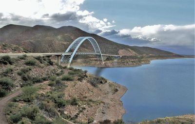 Arch bridge over mountains against sky