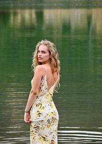 Beautiful young woman standing in lake