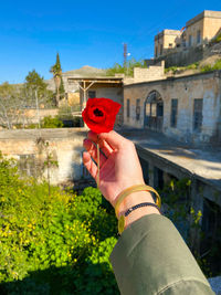 Midsection of person holding umbrella against built structure
