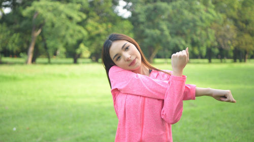 Portrait of smiling young woman standing on field