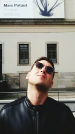 Portrait of young man wearing sunglasses standing outdoors