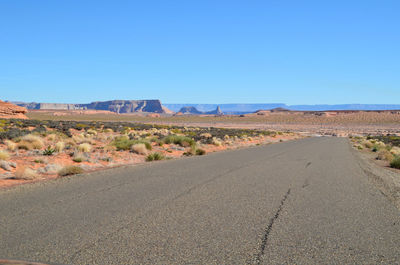 Empty road on landscape against clear blue sky at antelope canyon