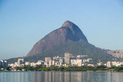 View of buildings by sea against clear sky