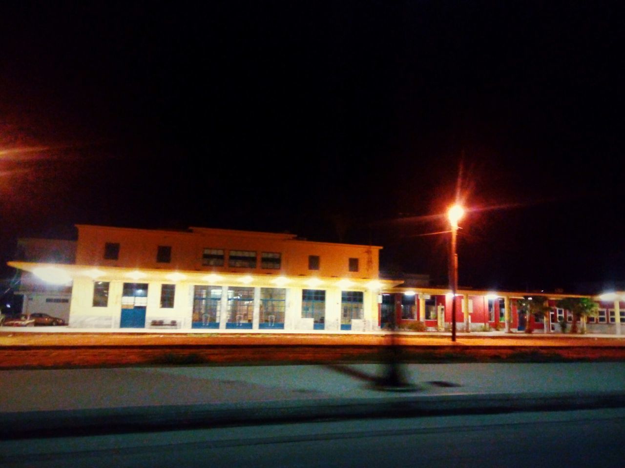 ILLUMINATED ROAD AGAINST BUILDING AT NIGHT