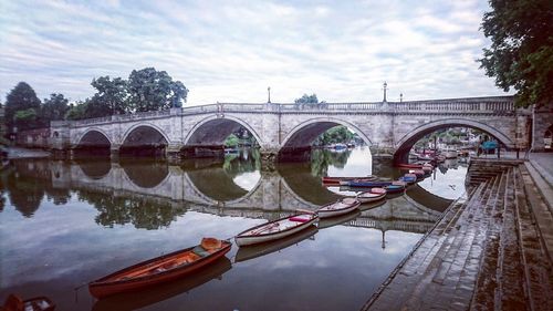 Arch bridge over river against sky