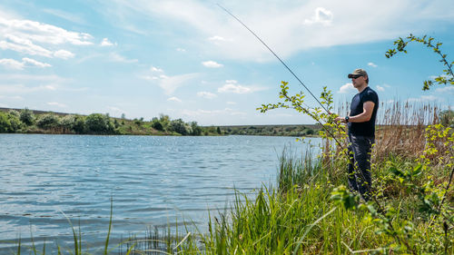 Fisherman with spinning rod on nature background. angler man with fishing spinning or casting rod