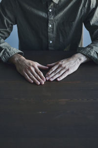 Midsection of man sitting by table
