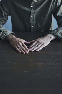 Midsection of man sitting on table