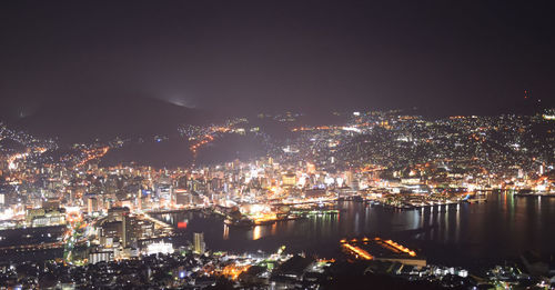 High angle view of illuminated buildings against sky at night