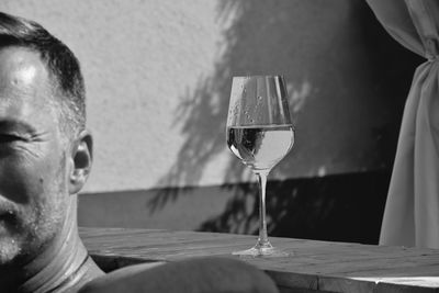 Close-up of man drinking glass on table
