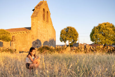 Rear view of woman standing on field against clear sky