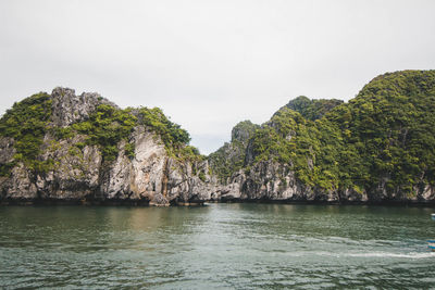 Scenic view of sea by rock formation against sky