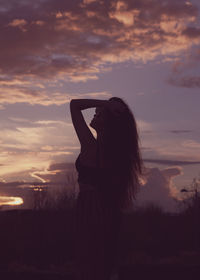 Rear view of woman on landscape at sunset