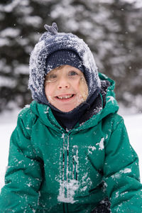 Portrait of smiling young woman standing on snow