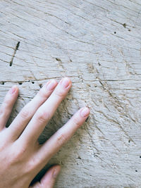 Close-up of person hand on wood