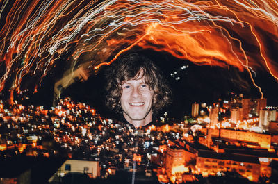 Digital composite image of man with illuminated cityscape and light painting at night