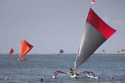 People in sea against sky